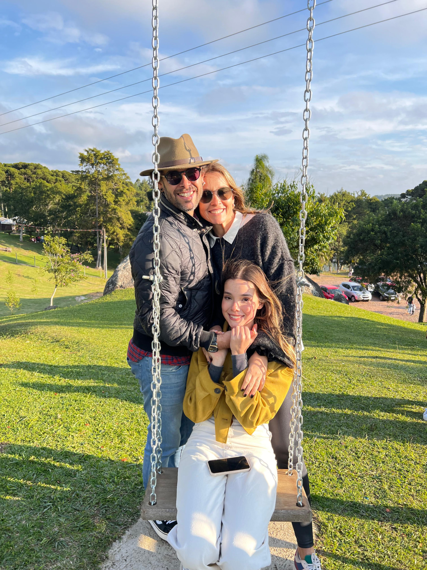 Max com a família em um balanço de madeira