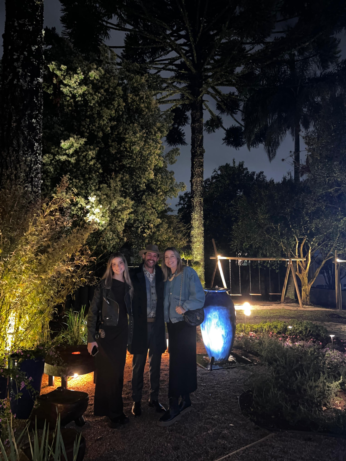 Max com a família em um jardim à noite