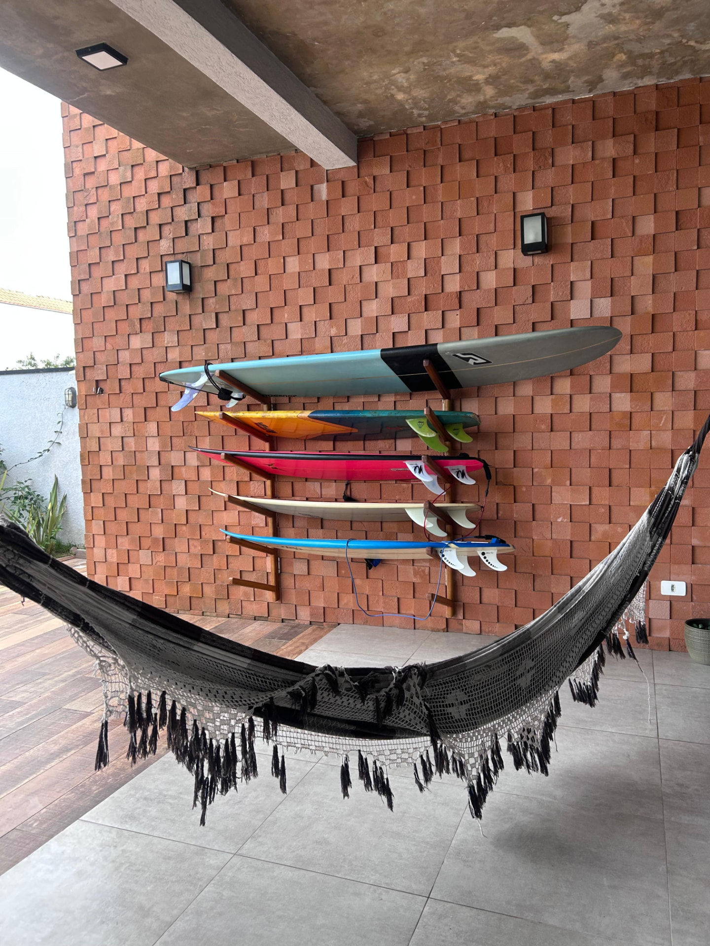 Pranchas organizadas na parede externa da Casa Alma de Surfista