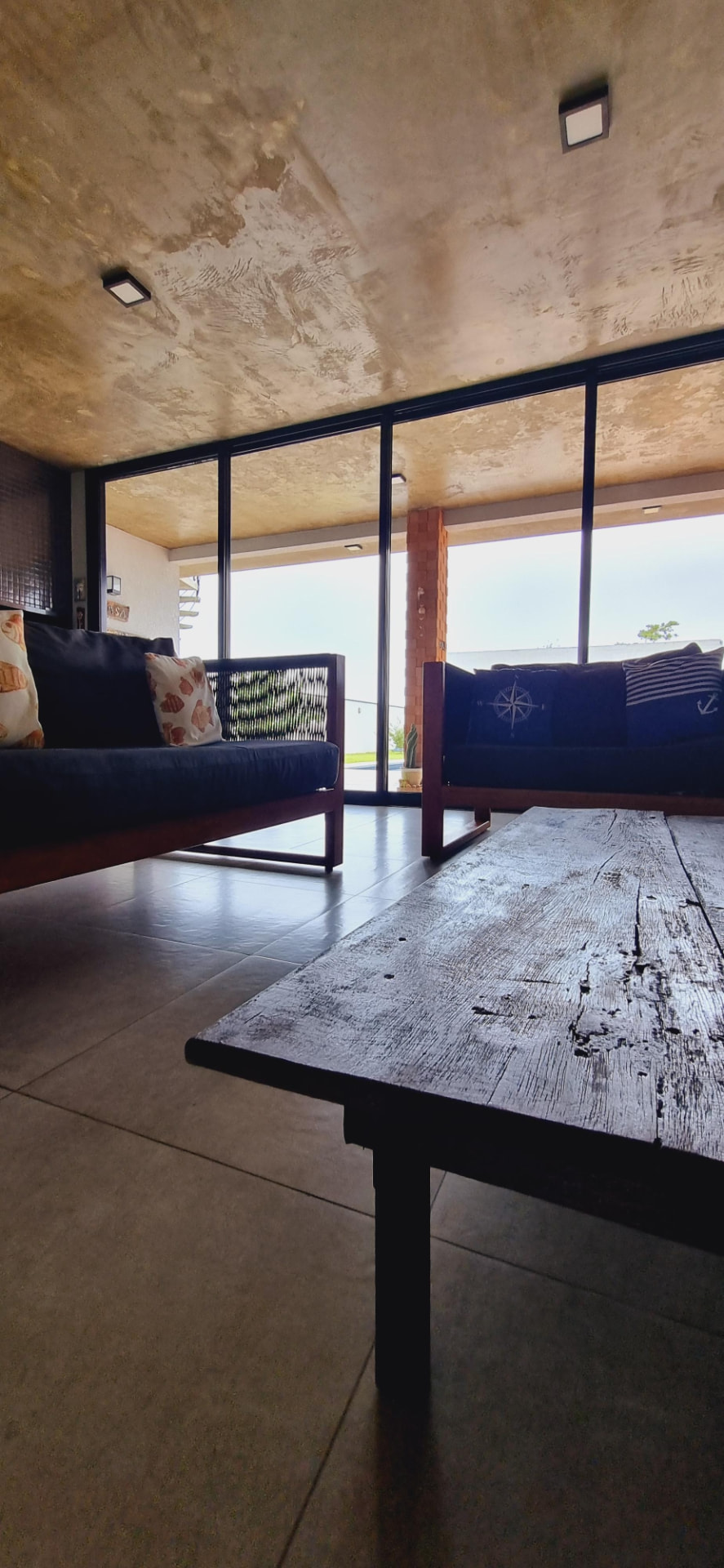Sala de estar da Casa Alma de Surfista com mesa e mobiliário em madeira