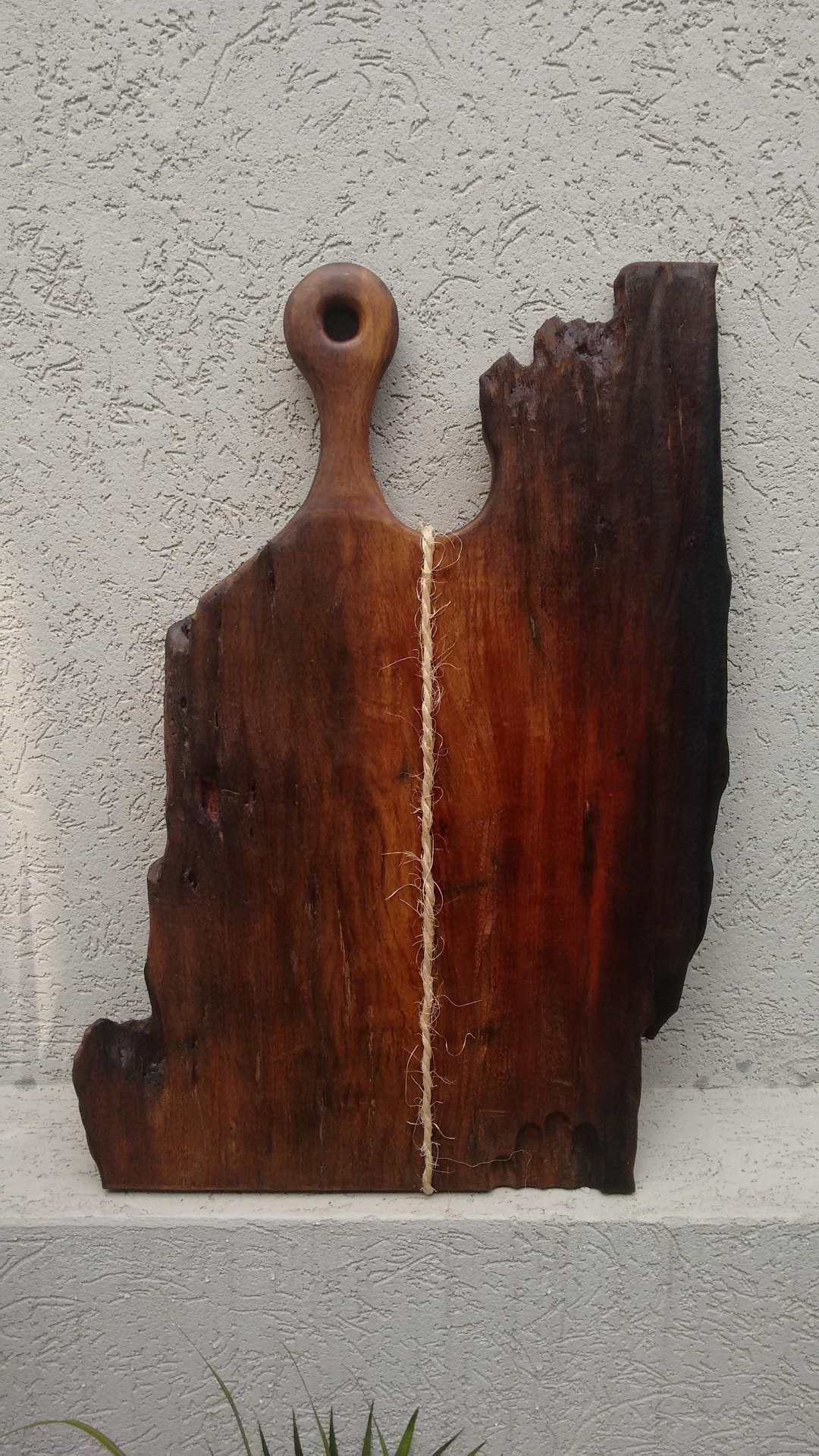 Tábua vertical em madeira escura com formato orgânico